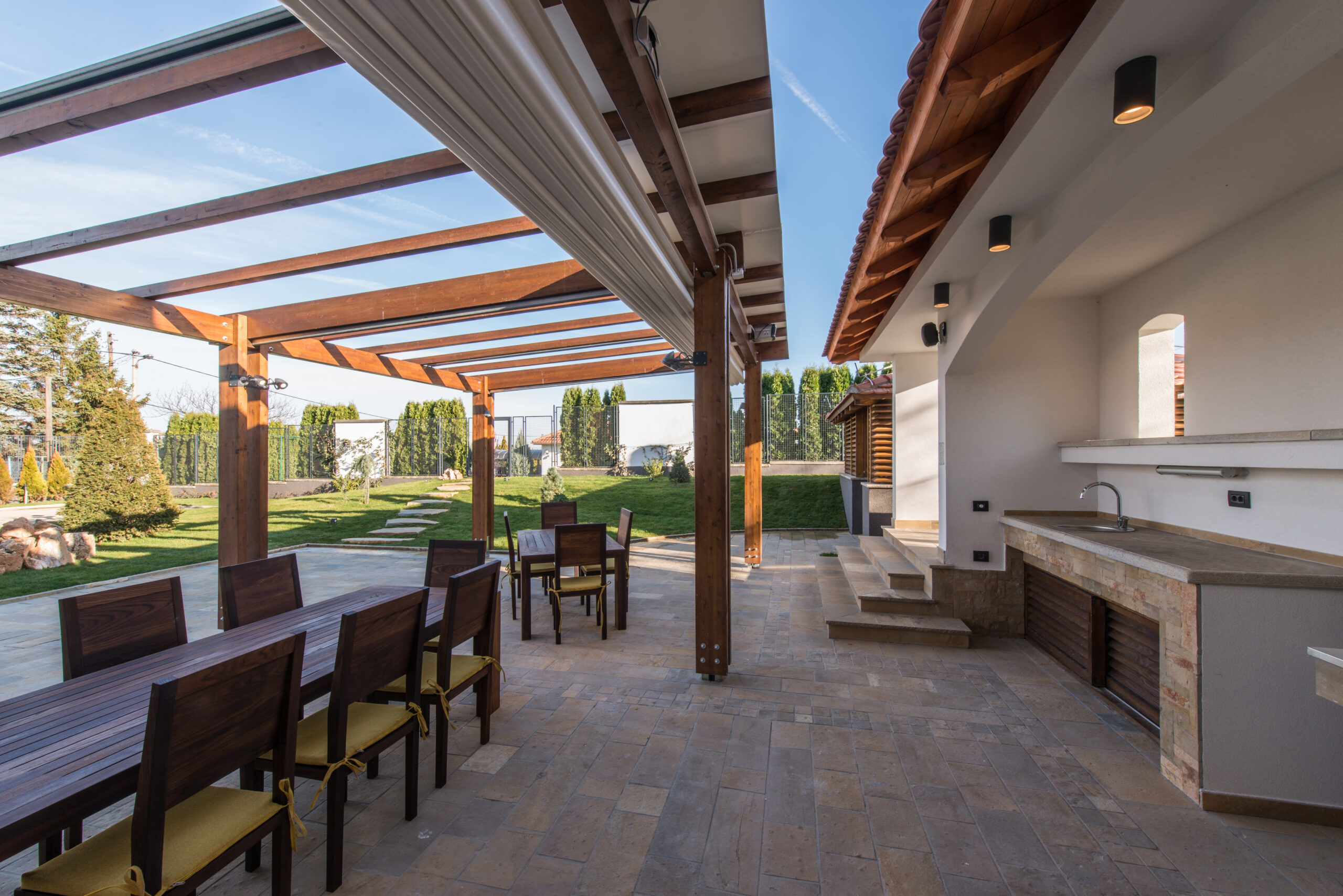 Beautiful terrace lounge with pergola and wooden table with chairs